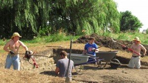 interns diggining earth camp foundation close up